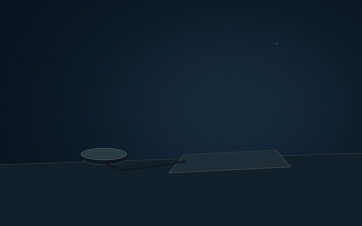 A GPS antenna puck beside a closed laptop at dusk